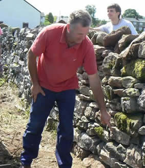 Dry Stone Walliing Workshop with Steve Allen at Greystoke Cycle Cafe - Steve points out to the group the parts he is most impressed with- the choice of stone is everything
